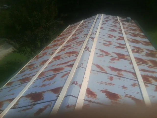Rusted metal roof panels with new wood purlins before replacement — Storm Damage Roof Repair in Prospect Park by Roofing Brothers