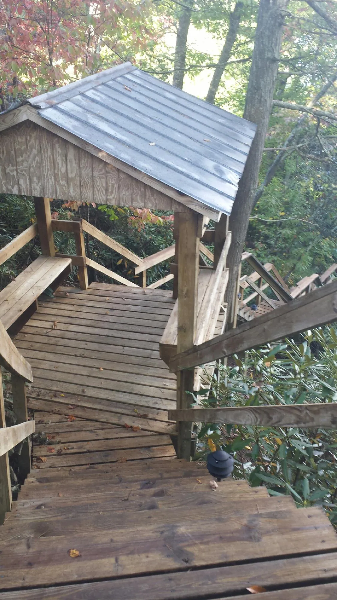 Metal roofed shelter over wooden steps on a wooded walkway — Skylight Repair & Installation work by our crew in Prospect Park