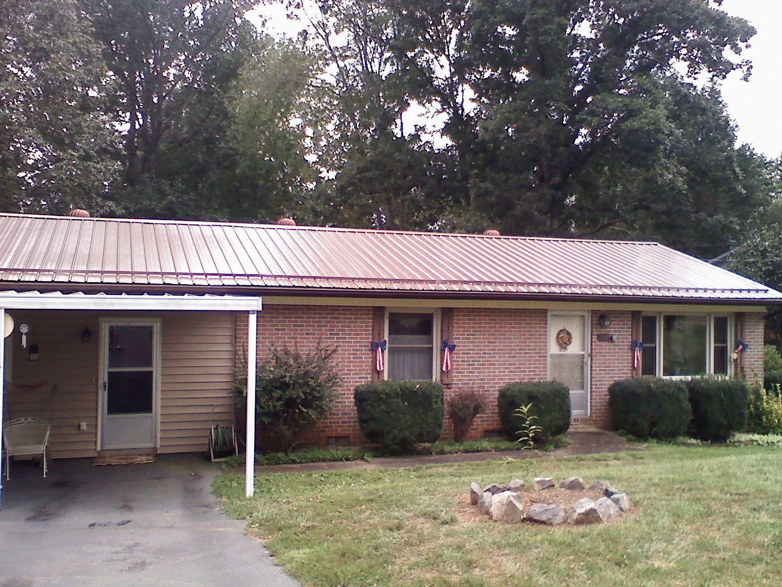 Bronze metal roof and carport on a brick ranch home — Roof Repair work by our crew in Prospect Park
